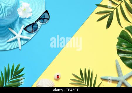 Tropical Background. Palm Trees Branches, hat with starfish and seashell on yellow and blue background. Travel. Copy space Stock Photo