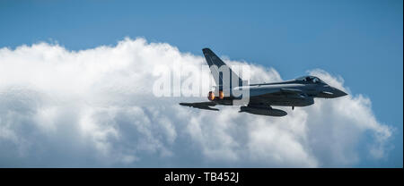RAF Typhoon airplane jet in the sky with white clouds and showing afterburner at the Duxford Air Show Stock Photo