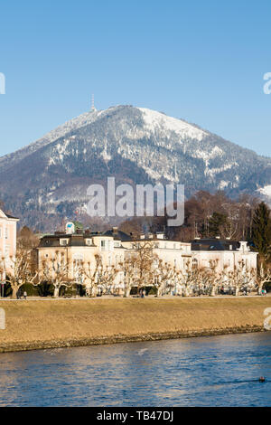 A winter view across the Salzach River in Salzburg, Austria.  In the background is snow capped Gaisberg a mountain to the East of the city. Stock Photo