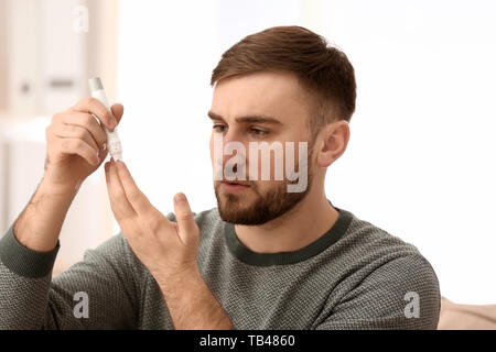 Diabetic man taking blood sample with lancet pen at home Stock Photo