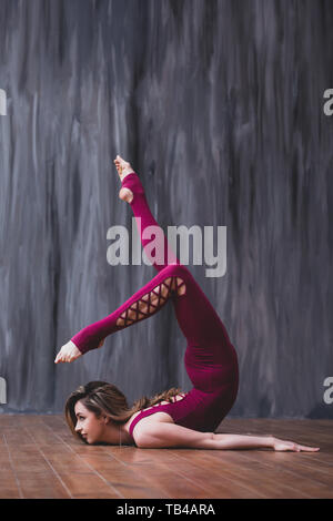 Beautiful young woman poses in athletic wear in urban setting - gymnastics  or cheer - stretching leg behind head - scorpion Stock Photo | Adobe Stock