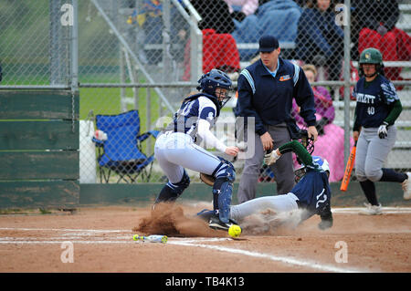 Runner slides in safely to the plate as throw from home was wild and eluded the catcher. USA. Stock Photo