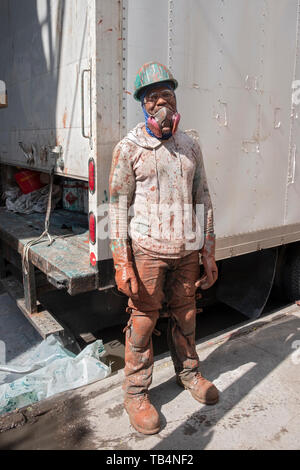 Posed portrait of a construction worker covered in paint on a subway renovation project on Roosevelt Ave. under the el in Queens, New York Stock Photo