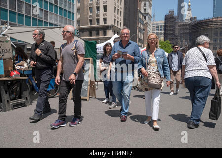 A middle aged tourist couple walk through the Union Square Green Market holding a map. In Manhattan, New York City. Stock Photo