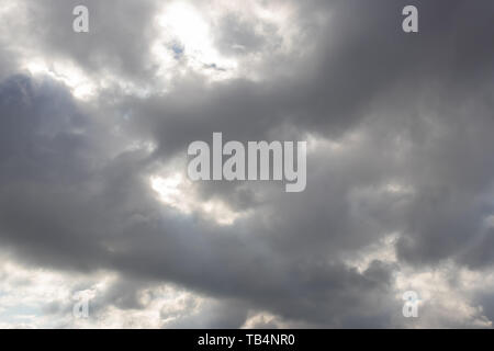 Heavy dark clouds with sunlight highlights and deep shadows Stock Photo