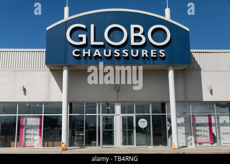 A logo sign outside of a Globo Shoes retail store location in