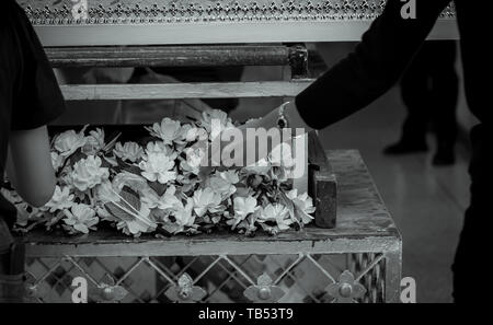 Funeral in Thailand. People put sandalwood flower to pay final tribute to the deceased. Thai Buddhist funerals. Wood cremation flower. Death Stock Photo