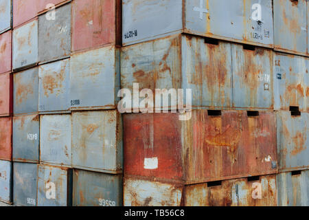 Stack of rusty metal containers stacked up rusty and marked, industrial waste, tall stack. Stock Photo