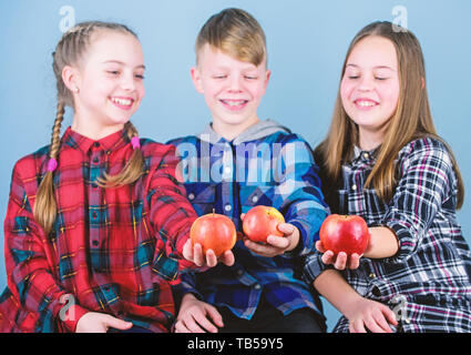 Promoting healthy nutrition. Group teenagers cheerful kids hold apples. Boy and girls friends eat apple. Teens with healthy snack. Healthy dieting and vitamin nutrition. Eat fruit and be healthy. Stock Photo