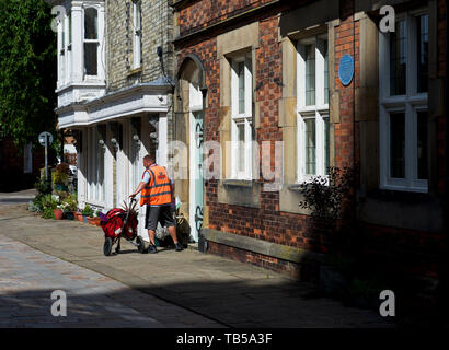 Postman on his delivery round in Howden, East Yorkshire, England UK Stock Photo