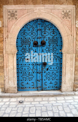 The traditional blue door of a 17th century house decorated with Islamic motifs in an alleyway of the medina (old city) of Tunis, Tunisia. Stock Photo
