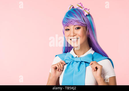 Smiling otaku girl in purple wig looking at camera isolated on pink Stock Photo