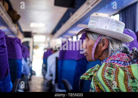 Elderly local woman sitting on the bus and wearing a fancy traditional hat in Chivay, Arequipa Region, Peru Stock Photo