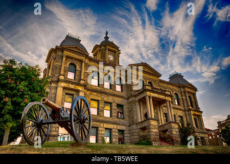 Cadiz, Ohio, USA- July 5, 2016: The Harrison County Courthouse standing in the background with a period Civil War canon displayed in the foreground. Stock Photo