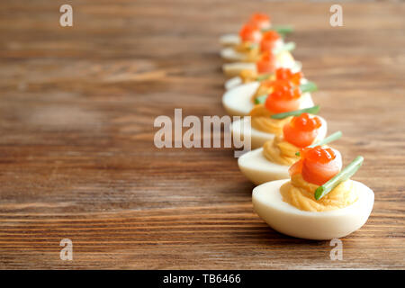 Tasty deviled eggs on wooden table Stock Photo