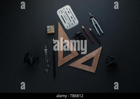 Drawing board flat lay with pencils, compasses, rulers and crumpled paper balls. The dark header for engineering, construction, and design with copy s Stock Photo