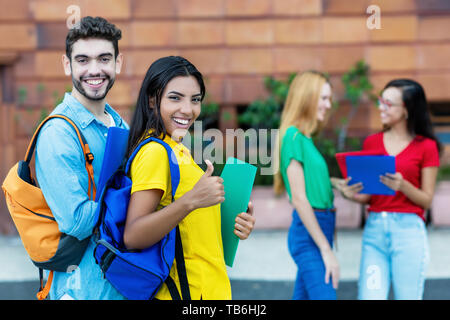 Successful caucasian male and latin american female student outdoors in summer Stock Photo