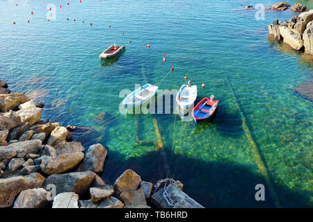 Colourful boats in tiny marina of Riomaggiore, the largest of the five centuries-old villages of Cinque Terre, located on rugged northwest coast of It Stock Photo