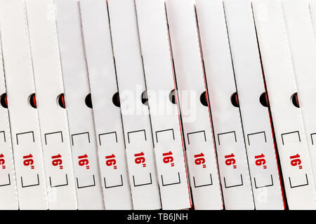 A large stack of white pizza boxes with red numbers diaimeter 16 Stock Photo