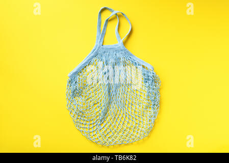 Reusable net bag or mesh shopper on yellow paper background. Zero waste, plastic free concept. Top view. Eco friendly reusable mesh shopper. Banner wi Stock Photo