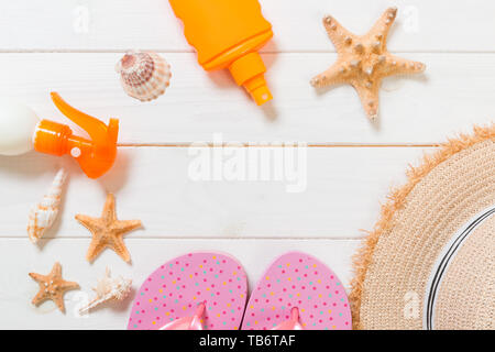 sun protection cream and other travel accessories on wooden background. Vacation healthcare accessories top view. Stock Photo