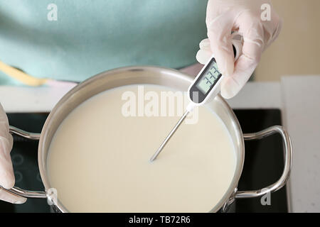 Woman preparing tasty cheese in kitchen, closeup Stock Photo