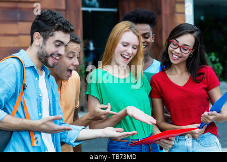 Group of international students is happy about good grades outdoors in summer Stock Photo