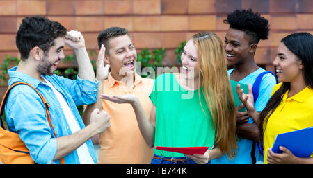 Group of students is happy about good grades outdoors in summer Stock Photo