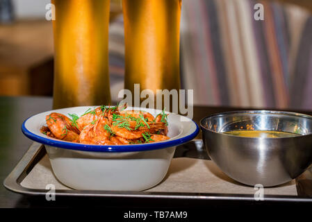 Prepared shrimps with dill in bowl on table with two beer glasses and water Stock Photo