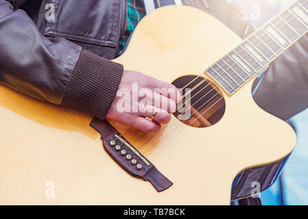 Man's hands playing acoustic guitar on the stage. Stock Photo