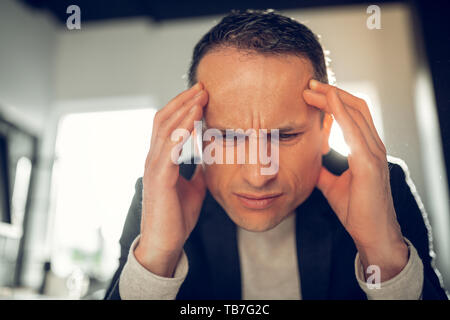 Businessman suffering from headache and high pressure Stock Photo