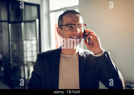 Mature CEO of company smiling while calling his wife Stock Photo
