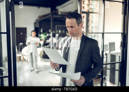 Mature serious businessman reading some report and documents Stock Photo