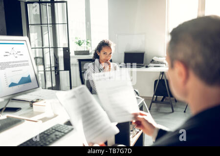 Curly dark-haired secretary feeling worried having job interview Stock Photo