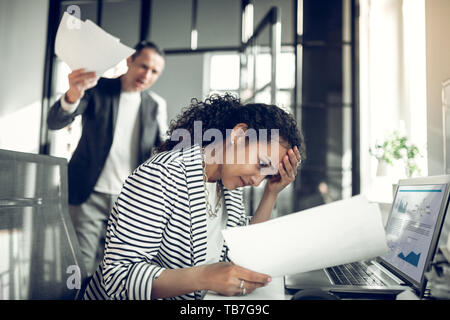 Dark-eyed employee feeling guilty for not completing the task Stock Photo