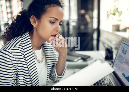 Woman working in the office feeling tired and thoughtful Stock Photo