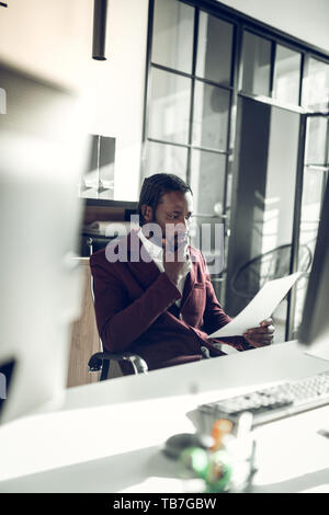 Bearded businessman wearing stylish jacket feeling thoughtful Stock Photo