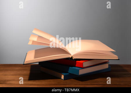Open books on table against grey background Stock Photo