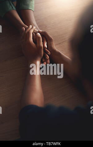 Man consoling girlfriend by holding her hands Stock Photo