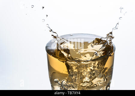 Close up of an ice cube splashing on a glass of Ginger Ale soft drink Stock Photo