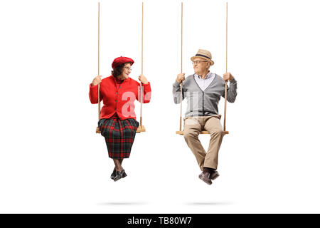 Full length portrait of an elderly couple on swings looking at each other isolated on white background Stock Photo