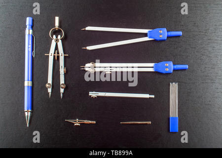 School Compasses Stationary Set on black wooden table Stock Photo