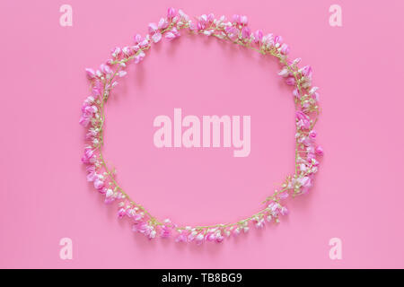 flat lay of Flower crown ,floral wreath circle made from pink flowers isolated on pink background, top view. flower creative composition with copy spa Stock Photo