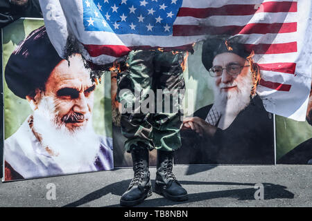 Tehran, Iran. 31st May, 2019. An Irani man burns the American flag during a protest marking the annual al-Quds Day (Jerusalem Day) on the last Friday of the Muslim holy month of Ramadan. Credit: Saeid Zareian/dpa/Alamy Live News Stock Photo