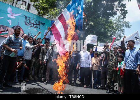 Tehran, Iran. 31st May, 2019. An Iranian man burns the US flag during a protest marking the annual al-Quds Day (Jerusalem Day) on the last Friday of the Muslim holy month of Ramadan. Credit: Saeid Zareian/dpa/Alamy Live News Stock Photo