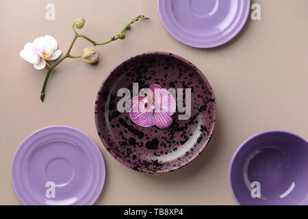 Composition with plates and orchid flowers on table Stock Photo
