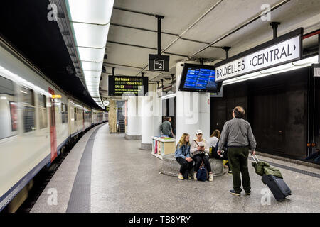 Passengers waiting on an underground platform in Brussels central station as an InterCity train is leaving. Stock Photo