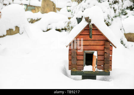 Wooden bird feeder in shape of house on winter day Stock Photo