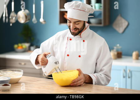 Male confectioner cooking tasty dessert in kitchen Stock Photo