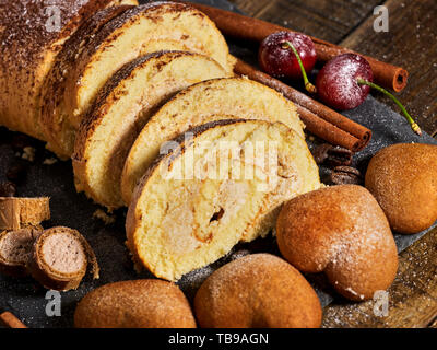 Sand cookies heart shape, rolled cake with cherry, cinnamon stick Stock Photo
